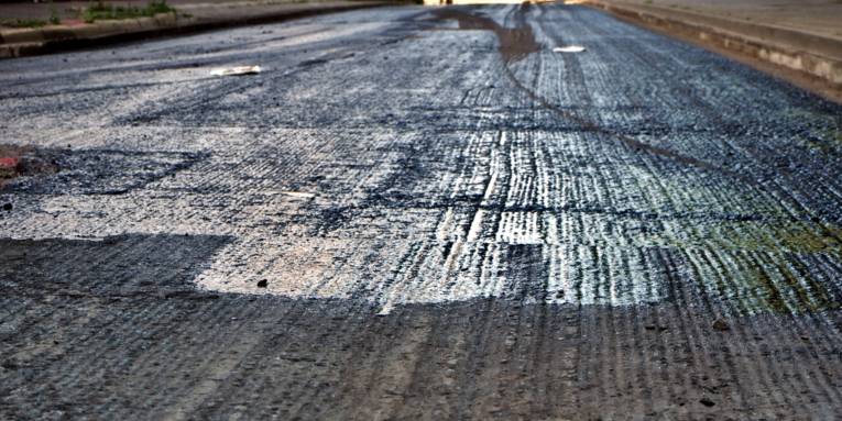 Die oberste Schicht einer Fahrbahn ist abgetragen, die Straße ist gesperrt.
