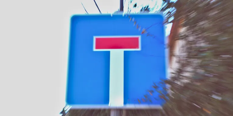 Reisszoom auf ein Schild, das auf eine Sackgasse hinweist.