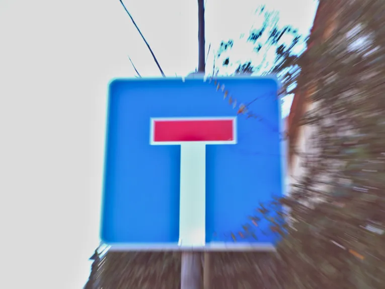 Reisszoom auf ein Schild, das auf eine Sackgasse hinweist.