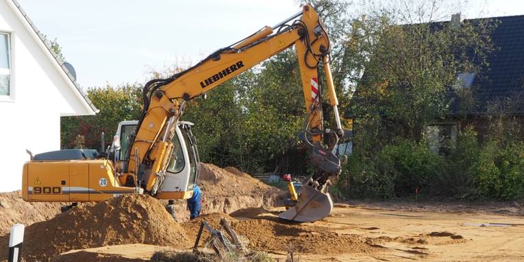 Der Boden eines Baugrundstücks wird für ein Fundament vorbereitet.