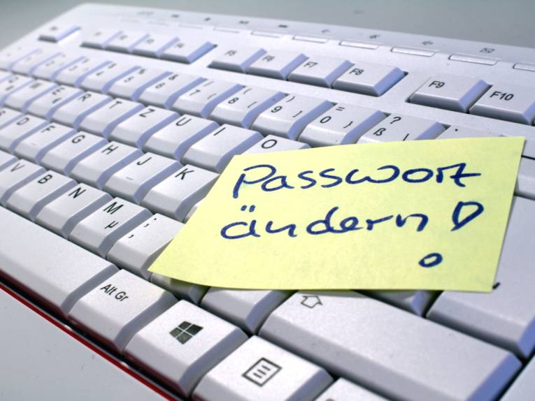 Auf einer Computertastatur klebt ein gelber Zettel, darauf steht handschriftlich "Passwort ändern".