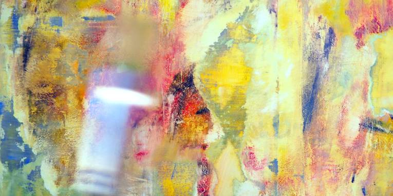 Verschiedene Pinsel vor einem farbigen Hintergrund.