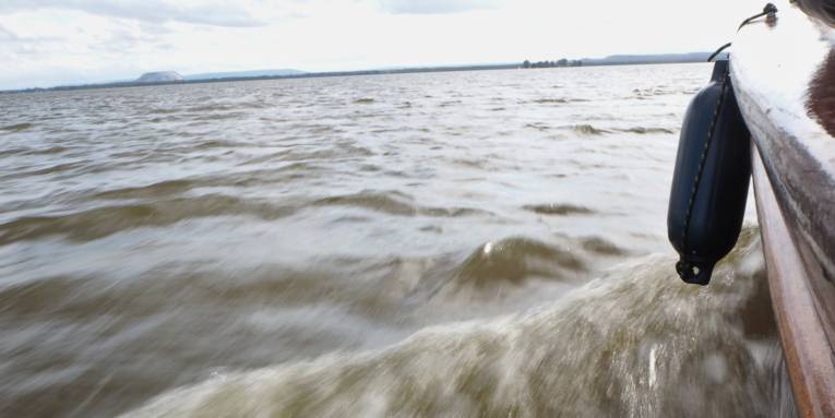 Ein Boot schiebt eine kleine Bugwelle vor sich her.