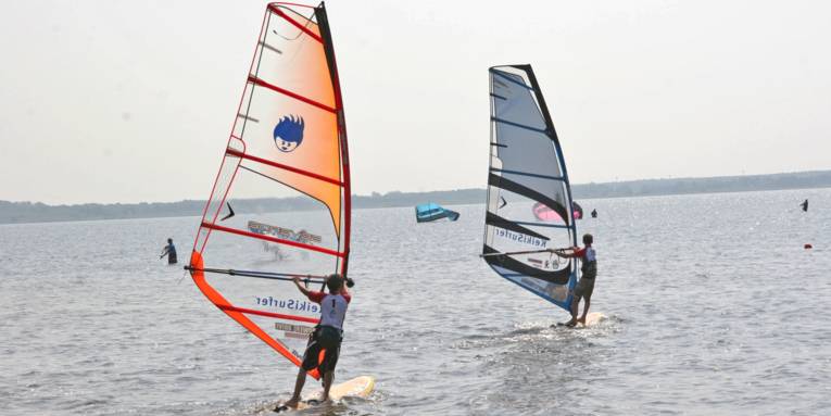 Zwei Windsurfer betreiben Wassersport auf dem Steinhuder Meer.