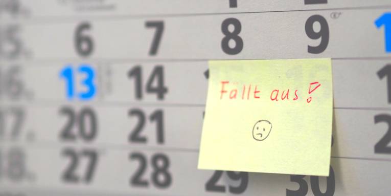 Auf einem Kalenderblatt klebt ein gelber Zettel. Auf dem Zettel steht in roter Handschrift "Fällt aus". Darunter ist ein zerknirschtes Gesicht.