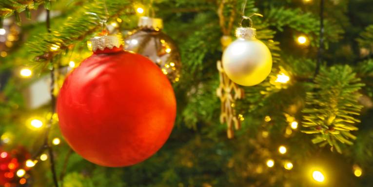 Die Zweige eines Tannenbaums sind mit Kugeln geschmückt.