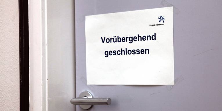Schild an einer Tür mit dem Text "Vorübergehend geschlossen", das Regionslogo ist oben rechts.