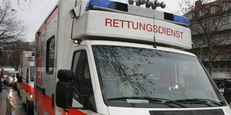 Mehrere Rettungswagen stehen hintereinander. Unter dem Blaulicht des vordersten Fahrzeugs steht in roter Schrift "RETTUNGSDIENST"