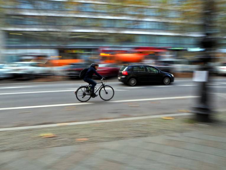 Ein Mann fährt auf einem Fahrrad durch den Stadtverkehr.