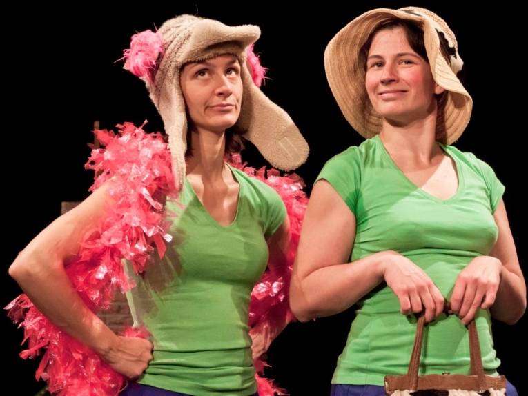 Szene aus dem Stück: zwei Frauen als Kühe verkleidet.