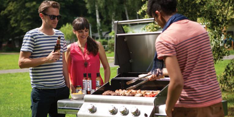 Drei Menschen am Grill