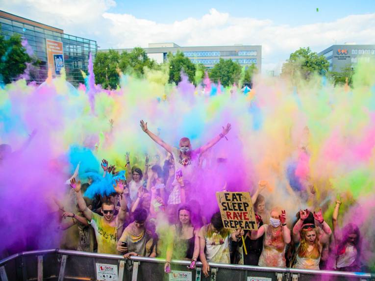 Feiernde Menschen werfen Farbbeutel