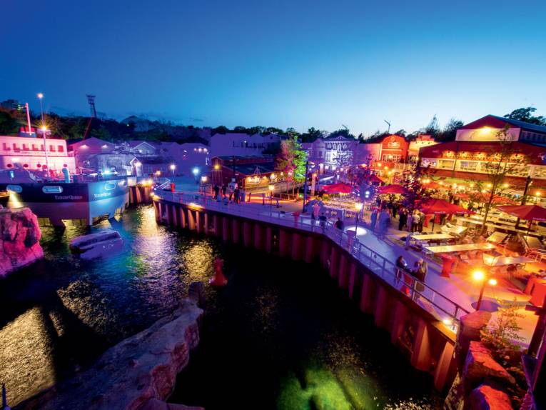 Stimmungsvoll beleuchteter Erlebnis-Zoo-Kongress in Hannover mit Wasser, Schiff und Westernstadt-Atmosphäre am Abend.