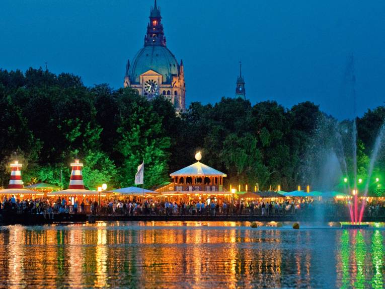 Hell erleuchtete Stände am See.