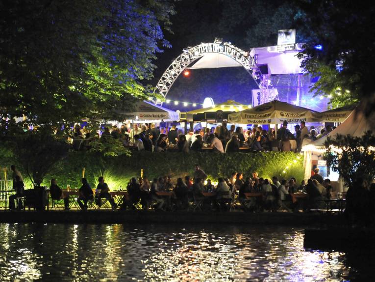 Blick vom See auf die hell erleuchtete Löwenbastion.