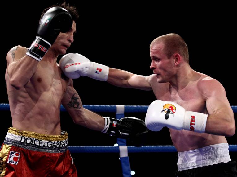 Zwei Boxer und ein Ringrichter im Ring.