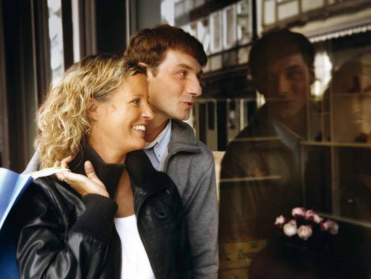 Zwei Menschen gucken in ein Schaufenster.