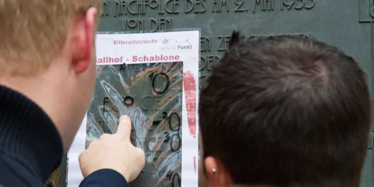 Zwei Männer untersuchen eine Steingravur.