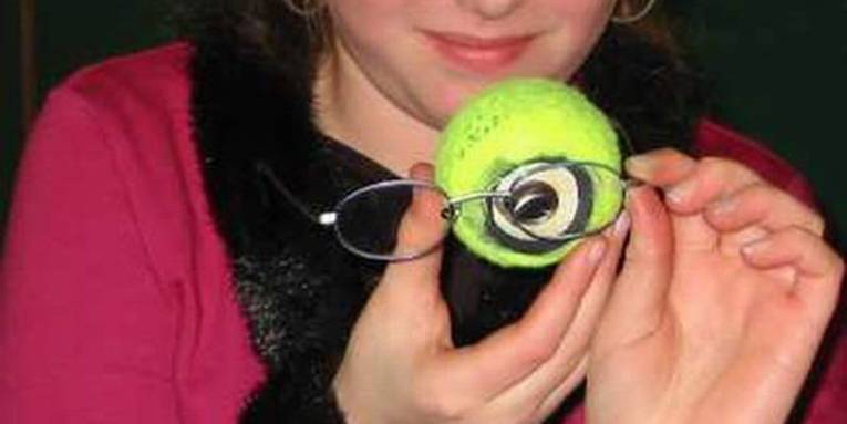Eine Brille vor einem selbst gebauten Augenmodell in Form eines Tennisballs