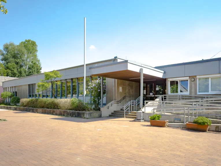 Ein Treppenaufgang und eine Rampe führen in das Flachgebäude der Grundschule Tegelweg.