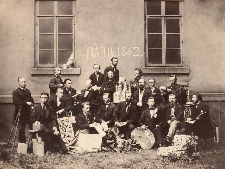 Conrad Wilhelm Hase mit Architekturstudenten im Hof der Polytechnischen Schule in der Georgstraße im Jahr 1862.