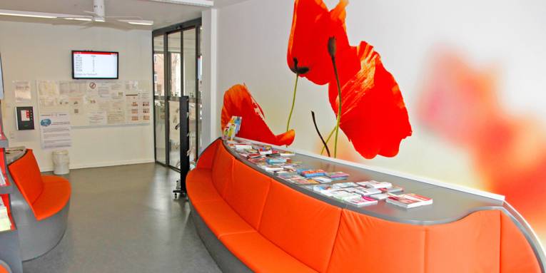 Ein großes geschwungenes Sofa und ein übergroßes Tulpenbild bestimmen den Wartebereich im Lindener Bürgeramt