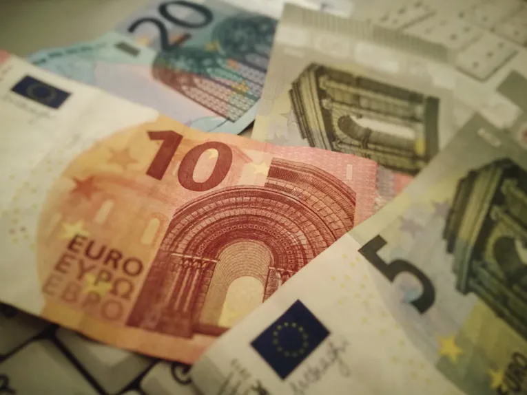 Symbolbild Geld: verschiedene Geldscheine auf einer Computertastatur
