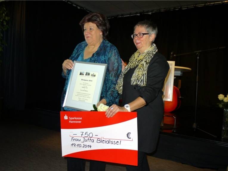 Frau Jutta Bleidissel erhielt von Bezirksbürgermeisterin Schlienkamp eine Urkunde, ein Scheck mit 750 Euro von der Sparkasse Hannover und eine weiße Rose überreicht.