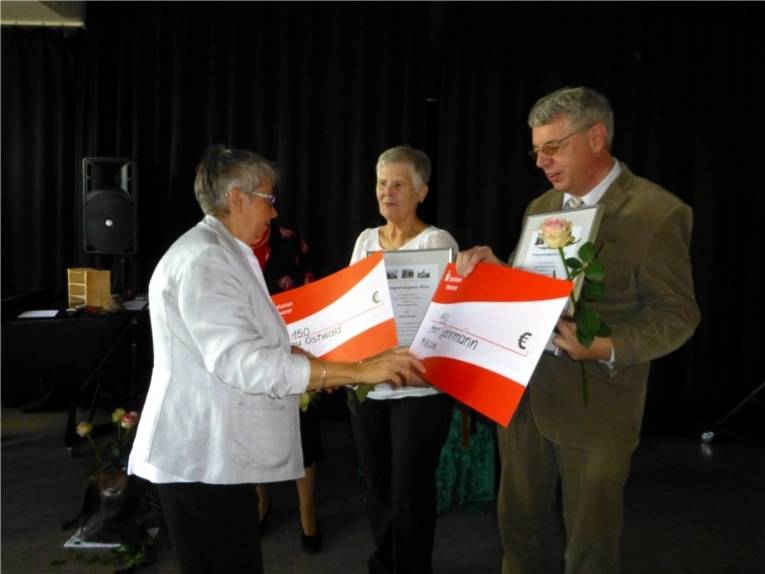 Bezirksbürgermeisterin Schlienkamp übergibt den symbolischen Scheck an Sigrid Ostwald und Rolf Gehrmann die Träger des Inegrationspreises 2016.