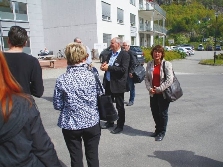 Die Delegation des Patenschaftskomitees und der Bürgermeister von Flekkefjord, stehen auf dem Parkplatz des Alten- und Pflegeheims.