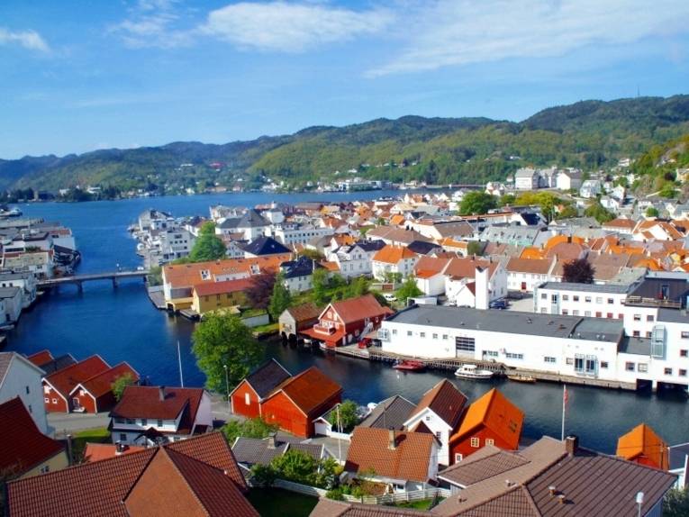 Die norwegische Stadt Flekkefjord von oben mit Blick auf die Gewässer und einem naheliegenden Wald.