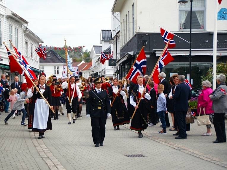 Eine Parade geht durch die Straßen Flekkefjords.
