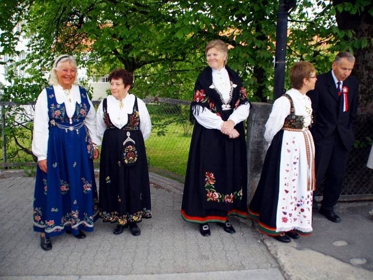 Vier gut gelaunte Frauen, die ihre traditionellen norwegischen Trachten tragen.