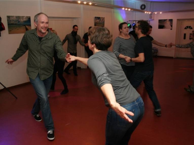 Mehrere Tanzpaare tanzen zusammen auf der Tanzfläche.