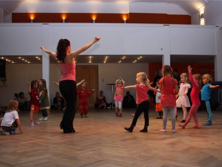Tanzende Kinder mit einer Tanzlehrerin.