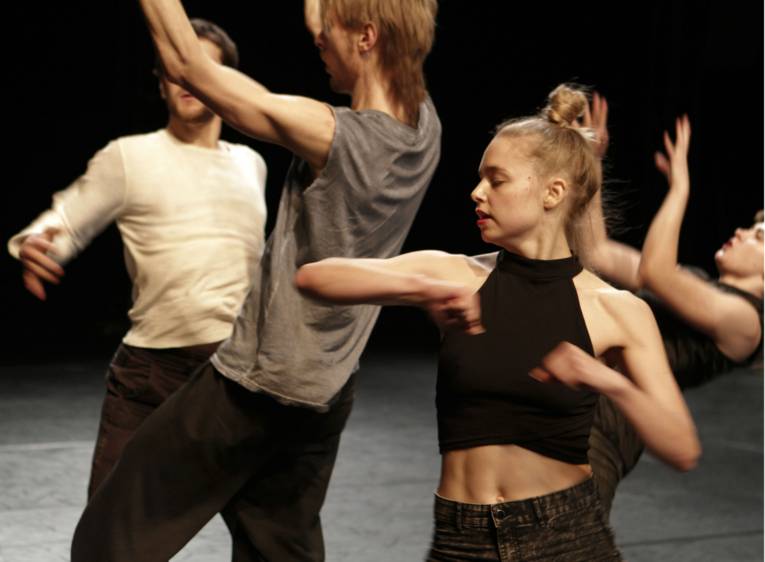 Gruppe tanzender Männer und einer Frau