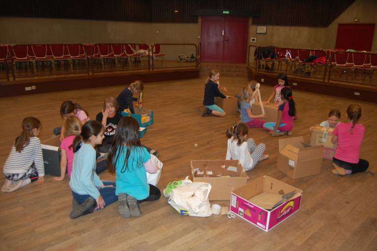 Die Kinder von Kinderzirkus Cirque d'Oehren packen Weihnachtspäckchen für eine Spendenaktion der Johanniter.