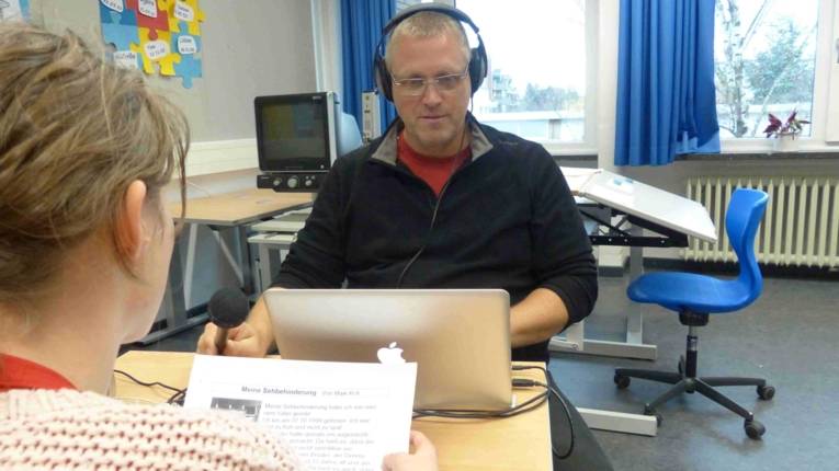 Internetradio MersiNews, eine Schülerin und der Redakteur bei den Aufnahmen.