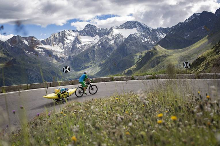 Ein Radfahrer vor der atemberaubenden Alpenkulisse.