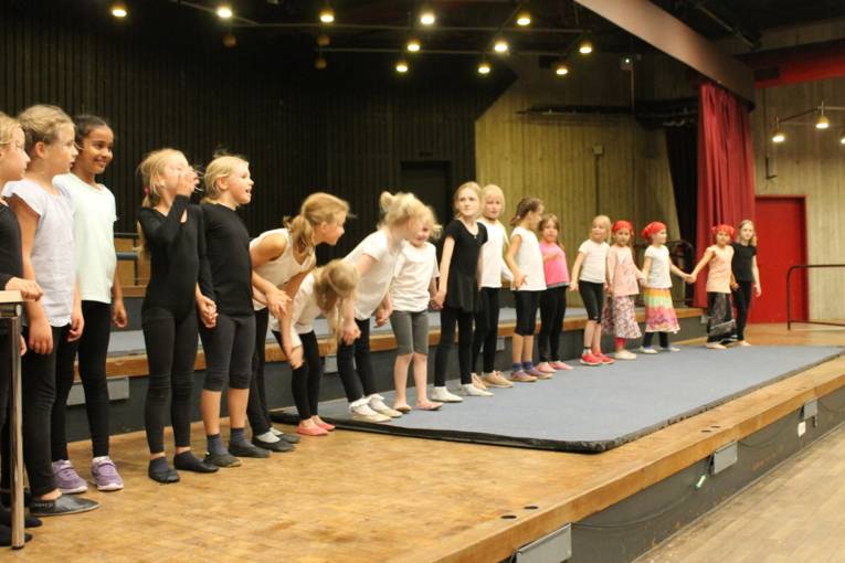 Alle Kinder vom Kinderzirkus stehen auf der Bühne und verbeugen sich nach dem gelungenen Auftritt.