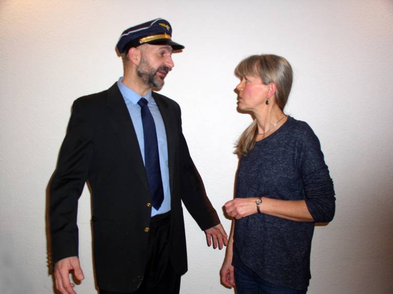 Ein Mann mit Pilotenuniform redet mit einer Frau.