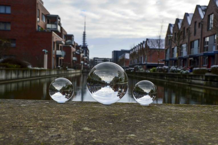 Blick in ein Hafenbecken durch drei Glaskugeln