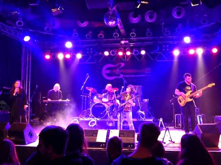 Forntalblick auf eine besetzte und ausgeleuchtete Bühne / während des Konzerts