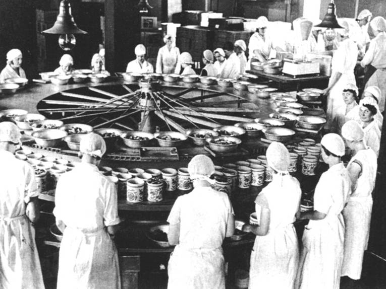 arbeitende Frauen an einem runden Fließband bei Fa. Bahlsen