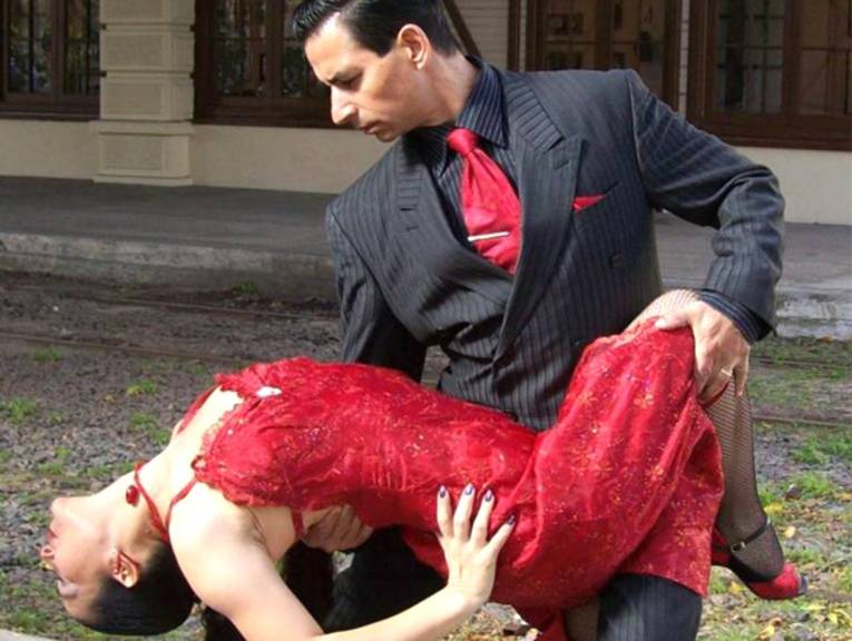Germán und Lili tanzen Tango, er im schwarzen Anzug und sie im roten Kleid