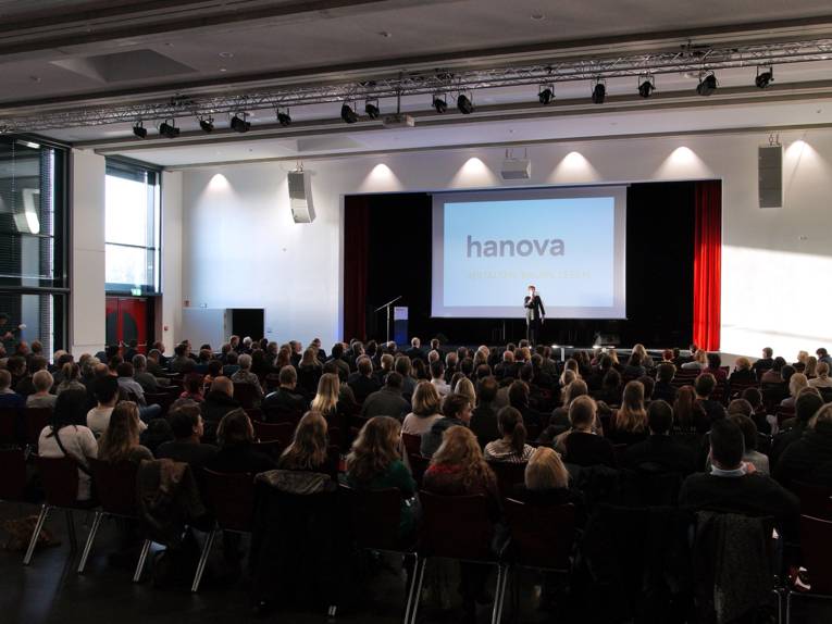 Aula mit Menschen. Auf der Bühne spielt eine Band. 