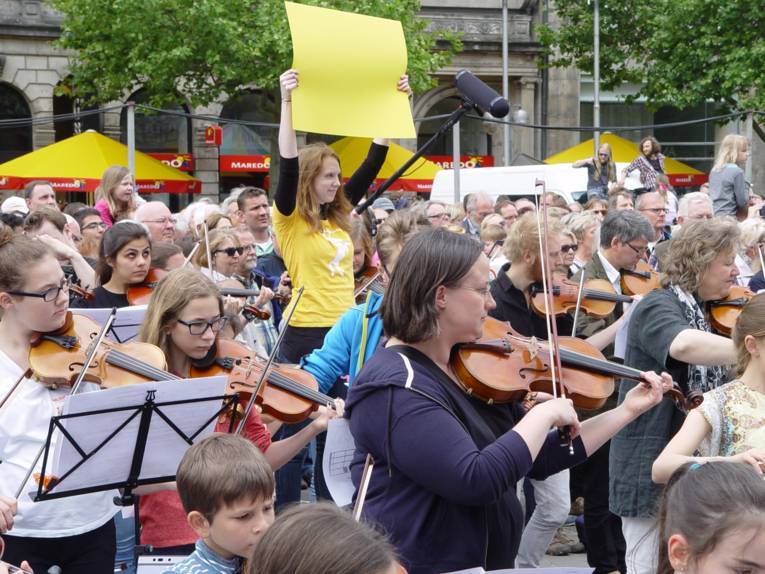 Phase gelb: In Phase gelb wird die Melodie der Romanze durch deren Auftakt-Figur hervorgelockt: Alle Streicher spielen sich unabhängig voneinander von vorne nach hinten durch 15 Stationen. Ist die Endphase erreicht, rote Schilder, beginnt der Violinenflashmob.