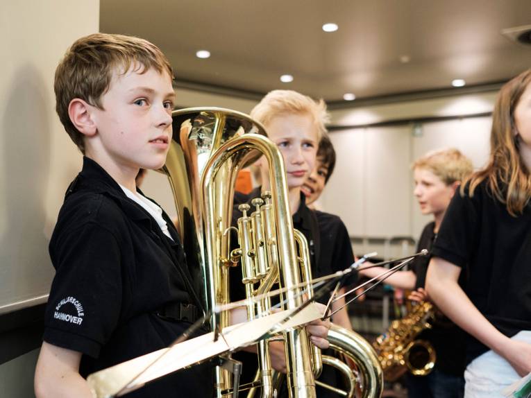 Vier Schüler der Bläserklasse Schillerschule mit Instrumenten vor ihrem Auftritt