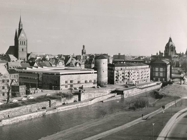 Foto von Heinz Koberg (heiko), um 1966: Hannover-Mitte, Am Hohen Ufer mit Leine, Historisches Museum mit Beginenturm, Klostergang. Im Hintergrund Turm der Marktkirche, Turm der Aegidienkirche und Neues Rathaus. Erhöhter Blickwinkel vom Preussag-Gebäude am Leibnizufer. 