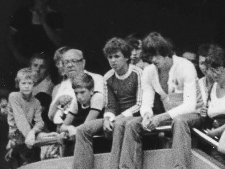 Zuschauer auf einer Mauer sitzend (Bildausschnitt vom Bild Jazzgymnastik in der Passarelle, heutige Niki-de-Saint-Phalle-Promendade)